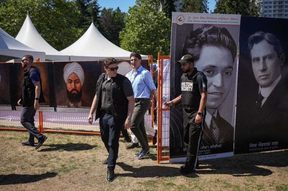 Prime Minister Justin Trudeau walks with his RCMP security detail as he arrives at the 28th annual Mela Gadri Babian Da festival in Surrey, B.C., Sunday, Aug. 4, 2024. TTHE CANADIAN PRESS/Darryl Dyck