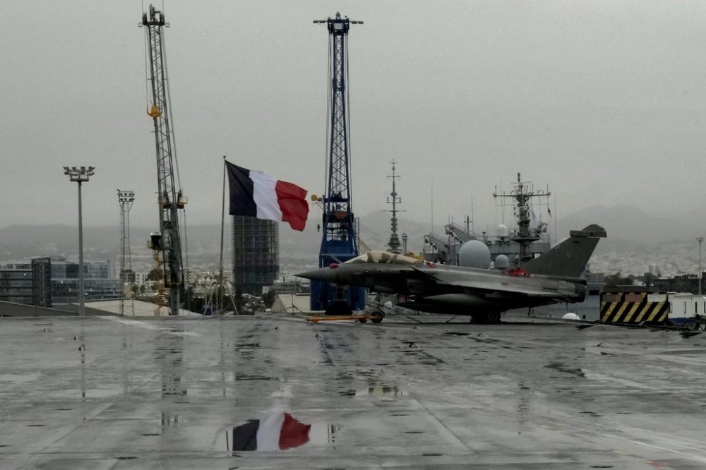 FILE - A Rafale jet fighter next to a French flag, on France's nuclear-powered aircraft carrier Charles de Gaulle, at Limassol port, Cyprus, Tuesday, March 1, 2022. AP Photo/Petros Karadjias, File)