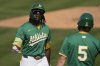 Athletics' Lawrence Butler, left, celebrates after his three-run home run with Jacob Wilson (5) during the second inning of a spring training baseball game against the Cincinnati Reds, Friday, Feb. 28, 2025, in Mesa, Ariz. (AP Photo/Carolyn Kaster)