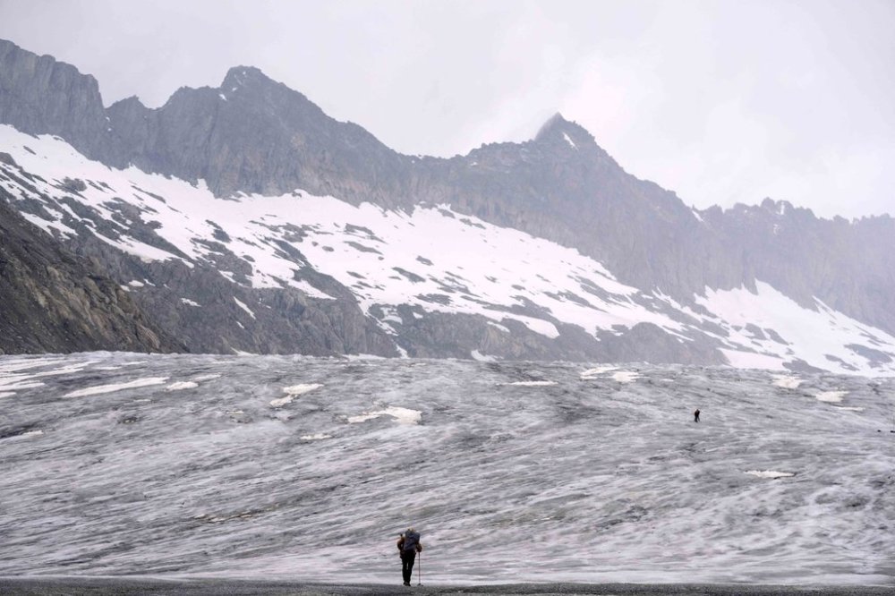 FILE - A cameraman walks up to the Rhone Glacier near Goms, Switzerland, Friday, June 16, 2023. (AP Photo/Matthias Schrader, File)