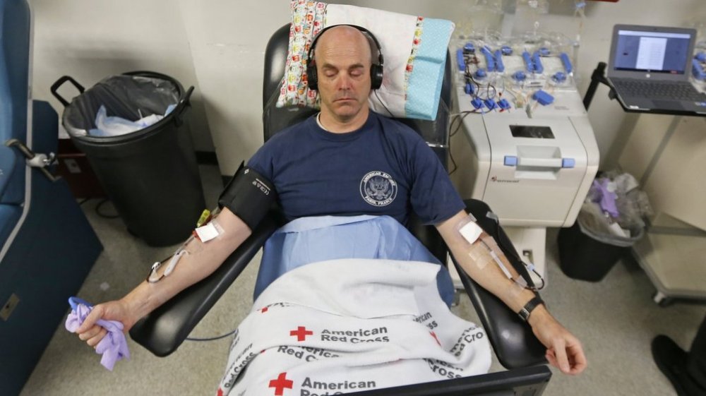 File - Eric Timpson gives blood at the American Red Cross Donation Center, March 23, 2020, in Murray, Utah. (AP Photo/Rick Bowmer, File)