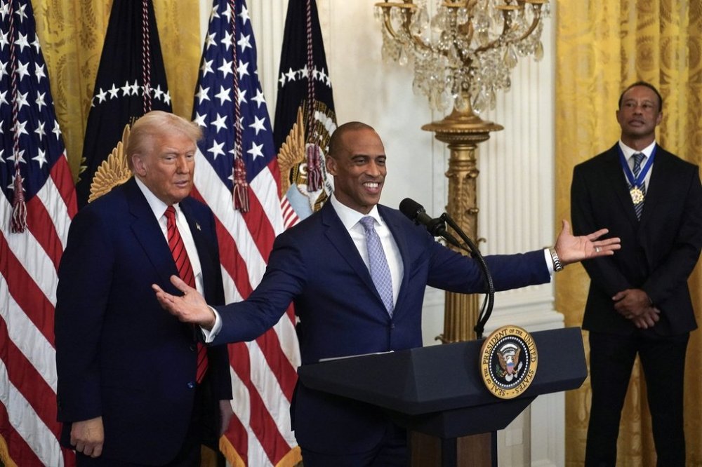 FILE - Housing and Urban Development Secretary Scott Turner speaks as President Donald Trump looks on during a reception in the East Room of the White House, Feb. 20, 2025. (Pool via AP, File)