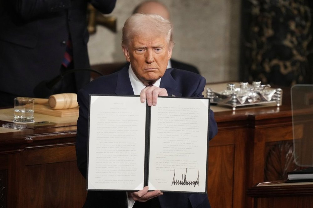 President Donald Trump holds up a signed executive order as he addresses a joint session of Congress at the Capitol in Washington, Tuesday, March 4, 2025. THE CANADIAN PRESS/AP, Alex Brandon