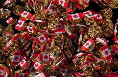Canadian pins are displayed on a table during launch celebrations for the 60th Anniversary of the National Flag of Canada Day, Friday, Feb. 14, 2025 in Ottawa.  THE CANADIAN PRESS/Adrian Wyld