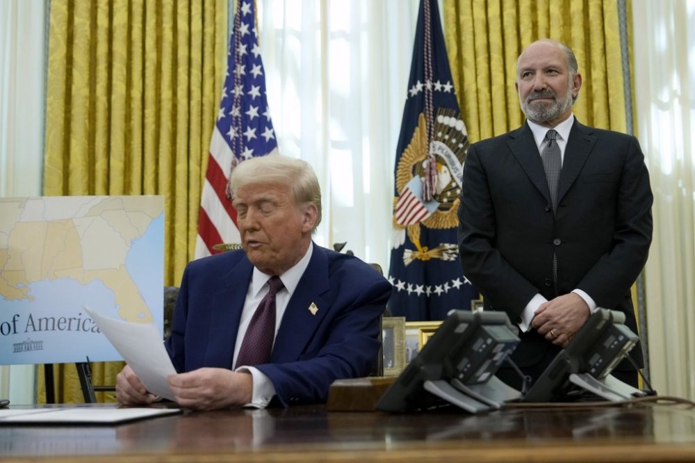 Commerce Secretary nominee Howard Lutnick listens as President Donald Trump speaks after signing an executive order in the Oval Office of the White House, Thursday, Feb. 13, 2025, in Washington. (AP Photo/Ben Curtis)