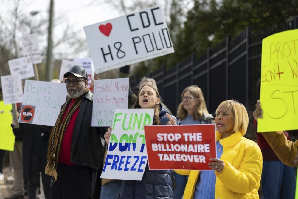 Demonstrators protest Centers for Disease Control and Prevention (CDC) layoffs in front of the CDC headquarters in Atlanta on Tuesday, Feb. 18, 2025. (Arvin Temkar/Atlanta Journal-Constitution via AP)