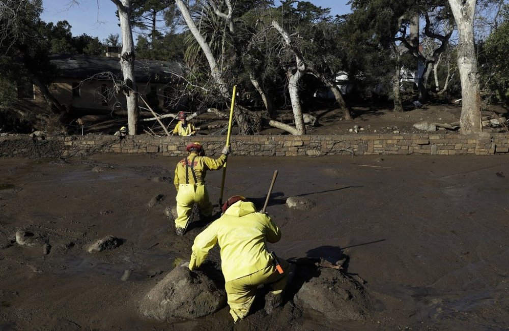 FILE - A Cal Fire search and rescue crew walks through mud near homes damaged by storms in Montecito, Calif., Jan. 12, 2018. (AP Photo/Marcio Jose Sanchez, File)