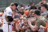 Baltimore Orioles shortstop Gunnar Henderson signs fans' balls before a spring training baseball game against the Pittsburgh Pirates, Saturday, Feb. 22, 2025, in Sarasota, Fla. (AP Photo/Stephanie Scarbrough)