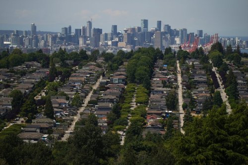 The downtown Vancouver skyline is seen in the distance beyond houses in Burnaby, B.C., July 12, 2023. THE CANADIAN PRESS/Darryl Dyck