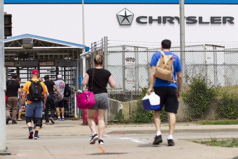 Workers arrive for their shift at the then Fiat Chrysler Automobiles assembly plant in Windsor, Ont., on June 12, 2018. The company is now known as Stellantis. THE CANADIAN PRESS/Geoff Robins