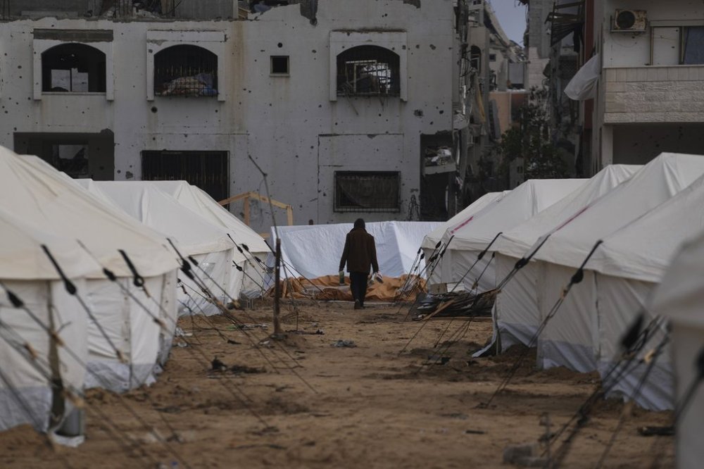 FILE - A man walks between tents for displaced Palestinians next to destroyed buildings following the Israeli air and ground offensive in Jabaliya, Gaza Strip, Thursday, Feb. 6, 2025. (AP Photo/Abdel Kareem Hana, file)