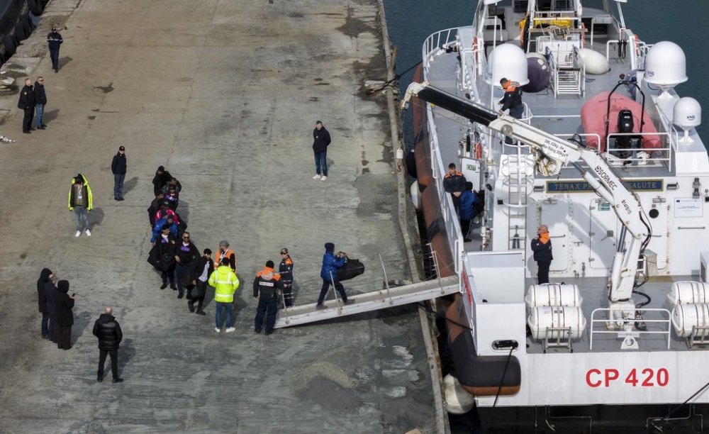 Migrants board an Italian Coast Guard vessel as part of a transfer operation from the asylum processing centers in Albania back to Italy following a court decision in Rome, at the port of Shengjin, northwestern Albania, Saturday, Feb. 1, 2025. (AP Photo/Vlasov Sulaj)
