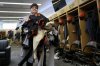 San Francisco Giants clubhouse attendant Riley Halpin gathers a mound of dirty clothes in the clubhouse after spring training baseball practice at the team's facility, Monday, Feb. 17, 2025, in Scottsdale, Ariz. (AP Photo/Carolyn Kaster)