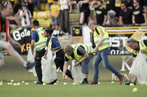 FILE - Pitch crews clean up after the home crowd threw tennis balls onto the pitch in a protest against VAR, shortly after kick-off in soccer match between Lillestrom and KFUM Oslo at Arasen Stadium in Oslo, June 27, 2024. (Amanda Pedersen Giske/NTB via AP, file)