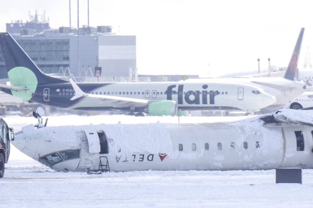 A Delta Air Lines plane lies upside down at Toronto Pearson Airport on Tuesday, Feb. 18, 2025. Flight 4819 — a Bombardier CRJ-900 jet operated by the Delta subsidiary Endeavor Air, crashed while landing in Toronto having flown from Minneapolis on Monday. THE CANADIAN PRESS/Chris Young