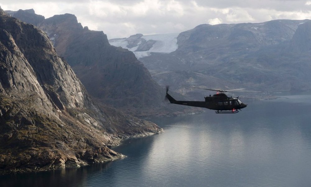 A Canadian military Griffon helicopter flies along the shoreline of Baffin Island on Aug. 26, 2014. THE CANADIAN PRESS/Adrian Wyld
