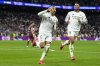 Real Madrid's Kylian Mbappe celebrates with Real Madrid's Jude Bellingham, right, after scoring his sides third goal during the Champions League playoff second leg soccer match between Real Madrid and Manchester City at the Santiago Bernabeu Stadium in Madrid, Spain, Wednesday, Feb. 19, 2025. (AP Photo/Manu Fernandez)