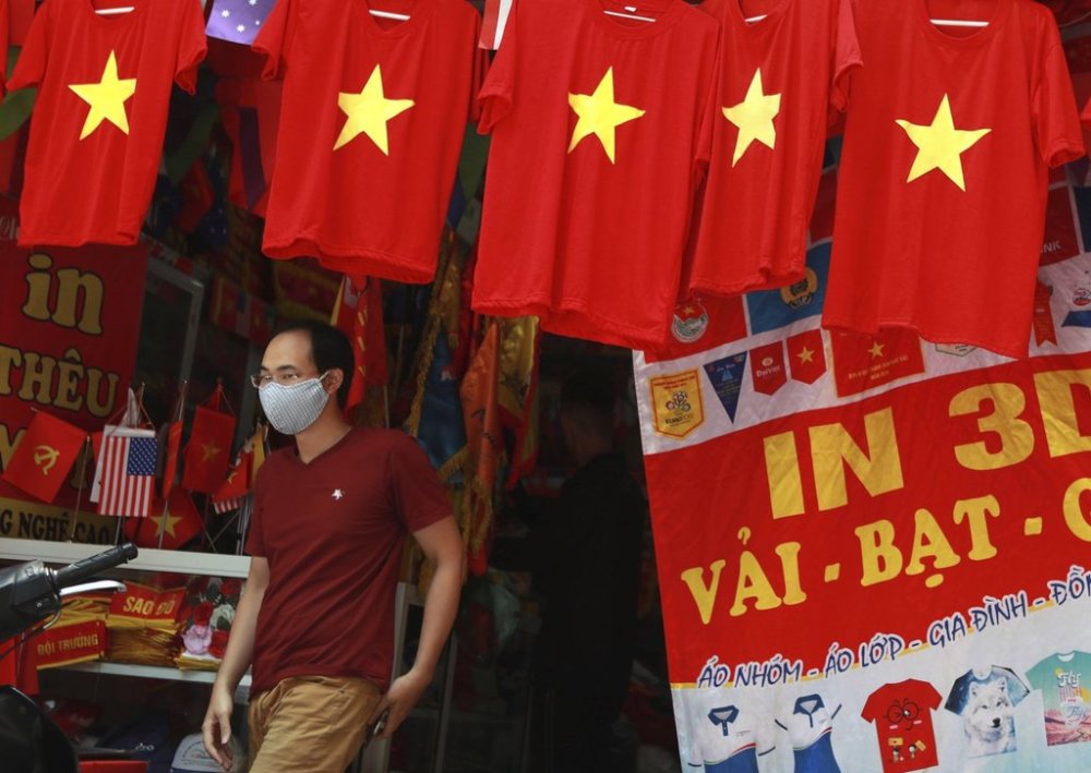 FILE - A man walks past a row of T-shirts printed with Vietnamese flags in Hanoi, Vietnam on July 30, 2020.(AP Photo/Hau Dinh, File)