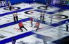 Reflected in a window of an arena suite; Canada second E.J. Harnden and third Mark Nichols, centre left, sweep as lead Geoff Walker watches his shot while playing Prince Edward Island during the Brier, in Regina, on Wednesday, March 6, 2024. The equipment technology tension that has engulfed the elite curling scene in recent weeks is expected to be put on hold at the Montana's Brier. THE CANADIAN PRESS/Darryl Dyck