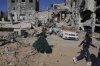 Palestinian girls dressed for Eid al-Fitr celebrations walk next to destructions in Jabaliya, Gaza Strip on Monday, March 31, 2025. (AP Photo/Jehad Alshrafi)