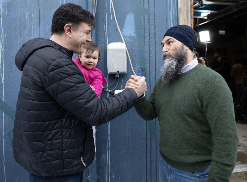 NDP Leader Jagmeet Singh, right is greeted by a supporter, Michael Bennett and his two-year-old daughter Riley following a federal election campaign stop in Ottawa on Saturday, March 29, 2025. THE CANADIAN PRESS/Christinne Muschi