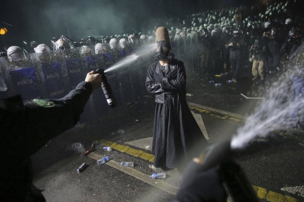 Riot police officers use pepper spray to clear a protester during a protest after Istanbul's Mayor Ekrem Imamoglu was arrested and sent to prison, in Istanbul, Turkey, Sunday, March 23, 2025. (AP Photo/Huseyin Aldemir)