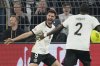 Germany's Tim Kleindienst, left, celebrates after scoring his side's third goal with Antonio Rudiger during the Nations League quarterfinal second leg soccer match between Germany and Italy at the Signal-Iduna Park in Dortmund, Germany, Sunday, March 23, 2025. (AP Photo/Martin Meissner)