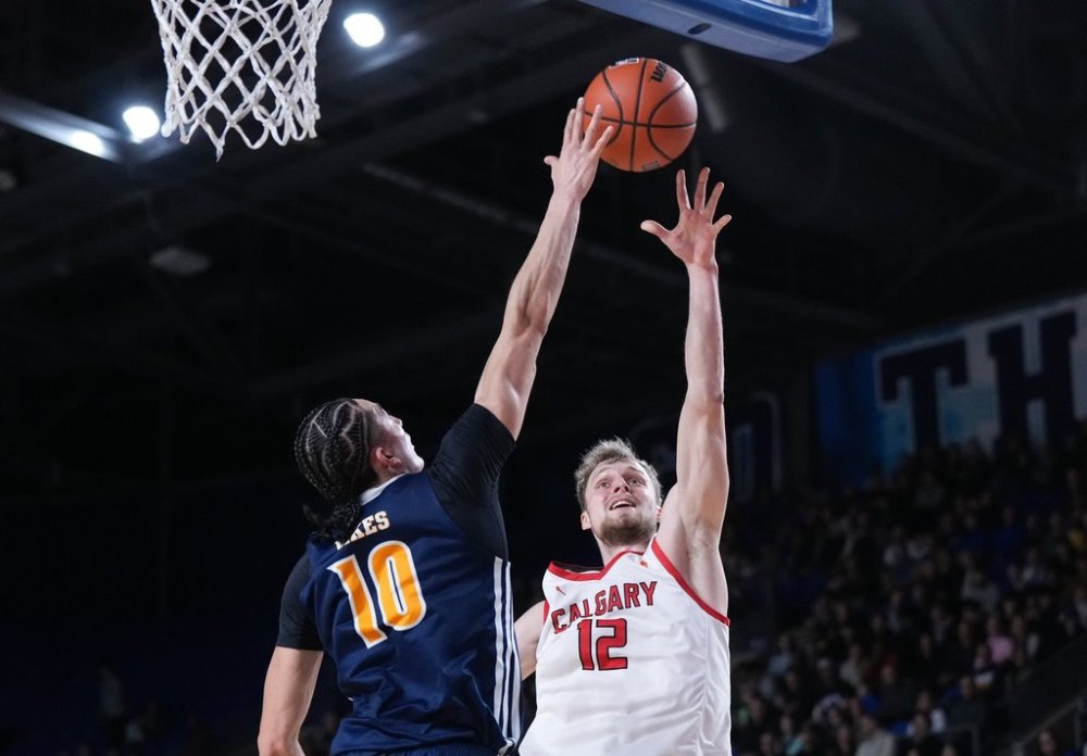 University of Calgary Dinos' Martynas Sabaliauskas (12) is blocked by University of Victoria Vikes' Shadynn Smid (10) during first half action at the U Sports men's national basketball championship final in Vancouver, B.C., Sunday, March 16, 2025. THE CANADIAN PRESS/Darryl Dyck