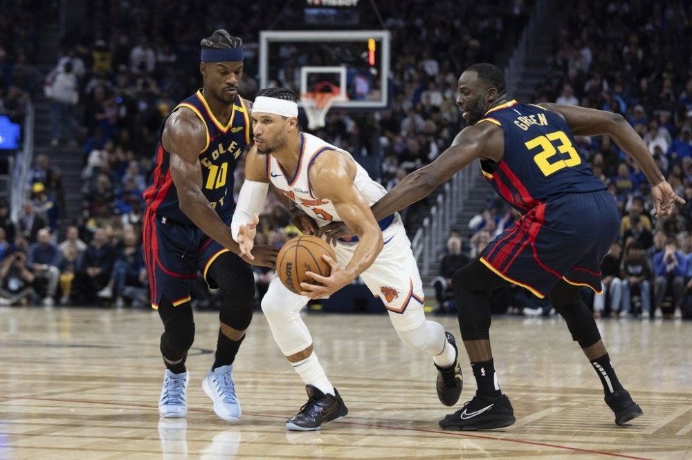 Golden State Warriors forward Jimmy Butler III (10) and forward Draymond Green (23) defend against New York Knicks guard Josh Hart during the first half of an NBA basketball game Saturday, March 15, 2025, in San Francisco. (AP Photo/Benjamin Fanjoy)