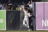 San Diego Padres right fielder Fernando Tatis Jr. can't make the catch at the wall off a hit for a double by Atlanta Braves' Matt Olson during the sixth inning of a baseball game Saturday, March 29, 2025, in San Diego. (AP Photo/Gregory Bull)