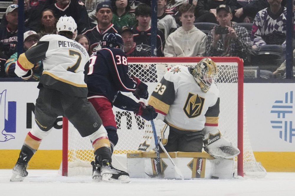 Vegas Golden Knights goaltender Adin Hill (33) blocks a shot by Columbus Blue Jackets center Boone Jenner (38) in the first period of an NHL hockey game Thursday, March 13, 2025, in Columbus, Ohio. (AP Photo/Sue Ogrocki)
