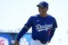 Los Angeles Dodgers manager Dave Roberts smiles at fans as he heads to the dugout prior to a spring training baseball game against the Cleveland Guardians, Tuesday, March 11, 2025, in Phoenix. (AP Photo/Ross D. Franklin)