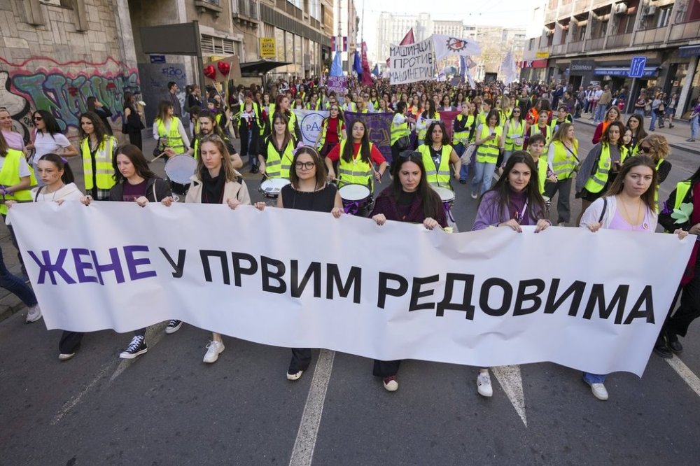 Women hold a banner reads: