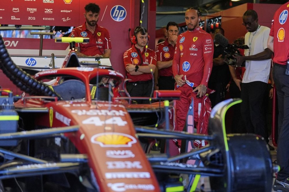 Ferrari driver Lewis Hamilton of Britain looks at his car ahead of the first practice session for the Australian Formula One Grand Prix at Albert Park, in Melbourne, Australia, Friday, March 14, 2025. (AP Photo/Asanka Brendon Ratnayake)