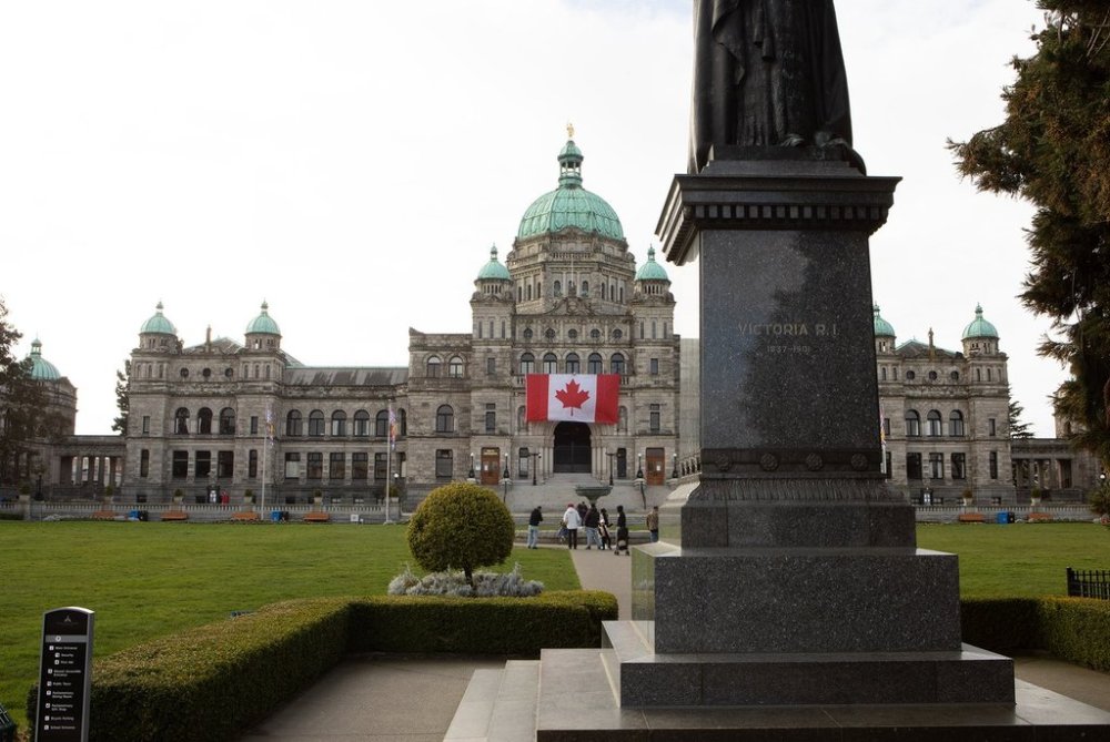 A large Canadian flag hangs over the ceremonial entrance at the legislature in Victoria, B.C., on Friday, March 7, 2025. THE CANADIAN PRESS/Chad Hipolito