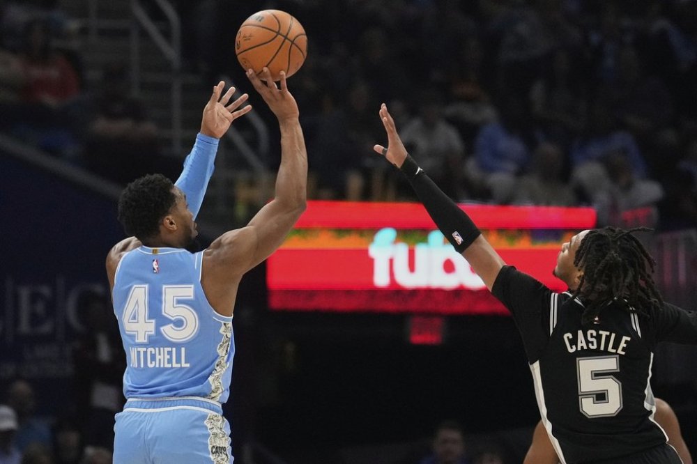 Cleveland Cavaliers guard Donovan Mitchell (45) shoots over San Antonio Spurs guard Stephon Castle (5) in the first half of an NBA basketball game Thursday, March 27, 2025, in Cleveland. (AP Photo/Sue Ogrocki)
