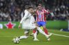 Atletico Madrid's Antoine Griezmann, right, is challenged by Real Madrid's Raul Asencio, left, and Real Madrid's Aurelien Tchouameni during the Champions League round of 16 first leg soccer match between Real Madrid and Atletico Madrid at the Bernebeu stadium in Madrid, Spain, Tuesday, March 4, 2025. (AP Photo/Manu Fernandez)