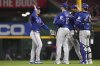 Texas Rangers' Wyatt Langford, center, high fives Nathan Eovaldi, center, at the conclusion of a baseball game against the Cincinnati Reds, Tuesday, April 1, 2025, in Cincinnati. (AP Photo/Kareem Elgazzar)