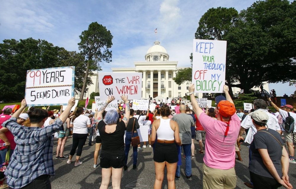 FILE - Protesters for women's rights hold a rally on the Alabama Capitol steps to protest a law passed the week before making abortion a felony in nearly all cases with no exceptions for cases of rape or incest, Sunday, May 19, 2019, in Montgomery, Ala. (AP Photo/Butch Dill, File)