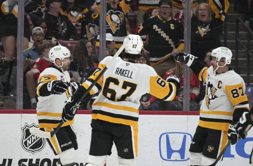 Pittsburgh Penguins right wing Bryan Rust (17) celebrates with right wing Rickard Rakell (67) and center Sidney Crosby (87) after scoring a goal during the first period of an NHL hockey game against the Florida Panthers, Sunday, March 23, 2025, in Sunrise, Fla. (AP Photo/Lynne Sladky)