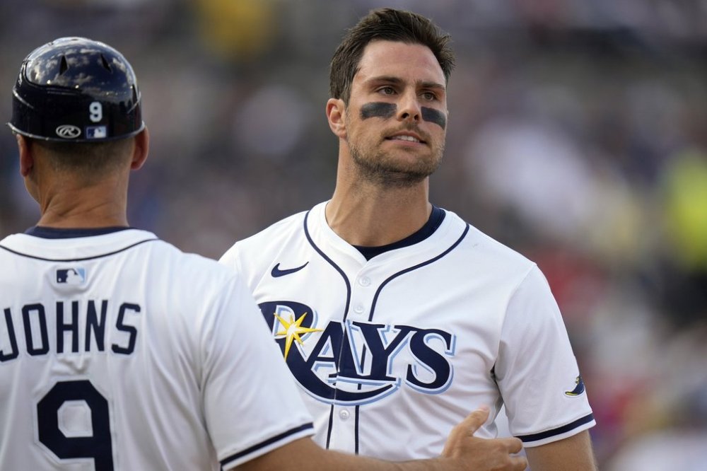 Tampa Bay Rays' Josh Lowe, right, winces in pain as he talks to first base coach Michael Johns (9) after his single during the fifth inning of a baseball game Friday, March 28, 2025, in Tampa, Fla. (AP Photo/Chris O'Meara)