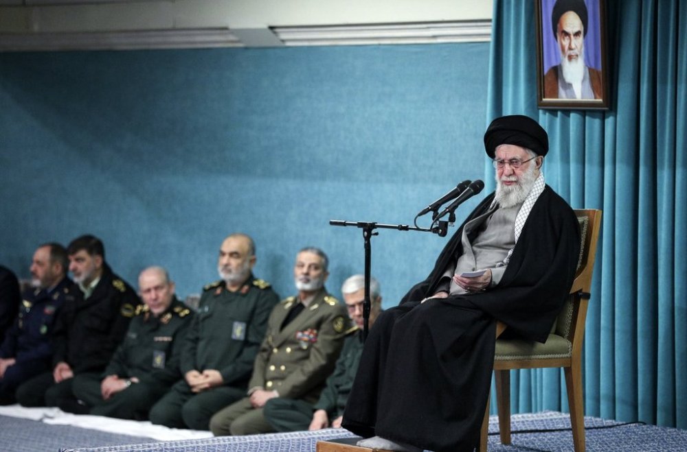 In this photo released by the official website of the office of the Iranian supreme leader, Supreme Leader Ayatollah Ali Khamenei speaks under a portrait of the late revolutionary founder Ayatollah Khomeini, as armed forces commander listen, at rear, in a ceremony meeting a group of officials, in Tehran, Iran, Saturday, March 8, 2025. (Office of the Iranian Supreme Leader via AP)
