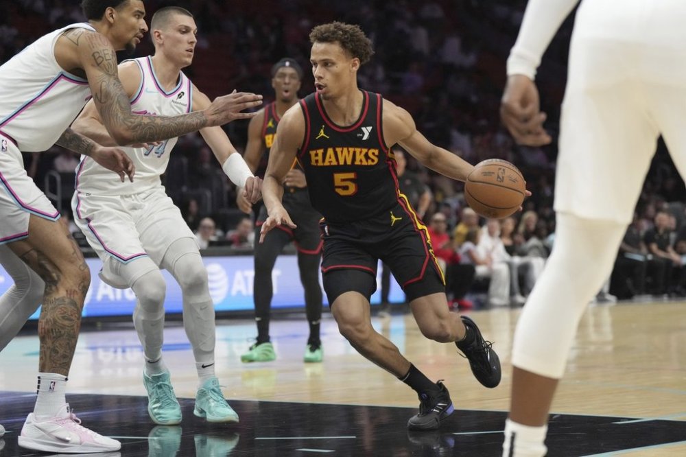Atlanta Hawks guard Dyson Daniels (5) drives to the basket as Miami Heat guard Tyler Herro (14) center Kel'el Ware (7), left, defend during the first half of an NBA basketball game, Thursday, March 27, 2025, in Miami. (AP Photo/Jim Rassol)