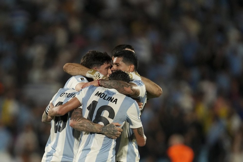 Argentina players celebrate defeating Uruguay during a qualifying soccer match for the FIFA World Cup 2026 in Montevideo, Uruguay, Friday, March 21, 2025. (AP Photo/Matilde Campodonico)