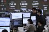 Currency traders watch monitors near a screen showing the Korea Composite Stock Price Index (KOSPI), top left, and the foreign exchange rate between U.S. dollar and South Korean won, top centre, at the foreign exchange dealing room of the KEB Hana Bank headquarters in Seoul, South Korea, Monday, April 7, 2025. (AP Photo/Ahn Young-joon)