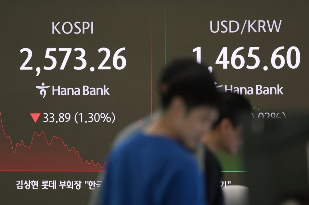Currency traders watch their computer monitors near the screens showing the Korea Composite Stock Price Index (KOSPI), left, and the foreign exchange rate between U.S. dollar and South Korean won at a foreign exchange dealing room in Seoul, South Korea, Friday, March 28, 2025. (AP Photo/Lee Jin-man)