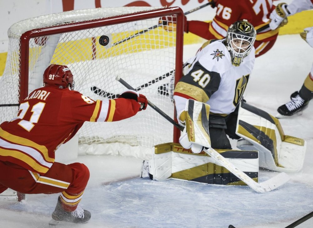 Vegas Golden Knights goalie Akira Schmid, right, looks on as Calgary Flames' Nazem Kadri tires to deflect the puck into the net during first period NHL hockey action in Calgary on Saturday, April 5, 2025. THE CANADIAN PRESS/Jeff McIntosh