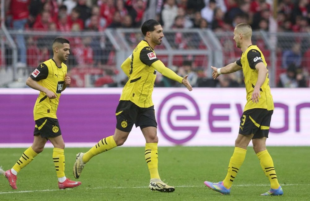 Dortmund's Emre Can, centre, celebrates after scoring his side's second goal during the German Bundesliga soccer match between Borussia Dortmund - FSV Mainz 05 at Signal Iduna Park in Dortmund, Germany, Sunday, March 30, 2025. (Bernd Thissen/dpa via AP)