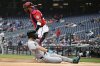 Arizona Diamondbacks' Corbin Carroll, bottom, slides home to score on a sacrifice fly by Geraldo Perdomo against Washington Nationals catcher Keibert Ruiz, top, during the first inning of a baseball game, Sunday, April 6, 2025, in Washington. (AP Photo/Nick Wass)