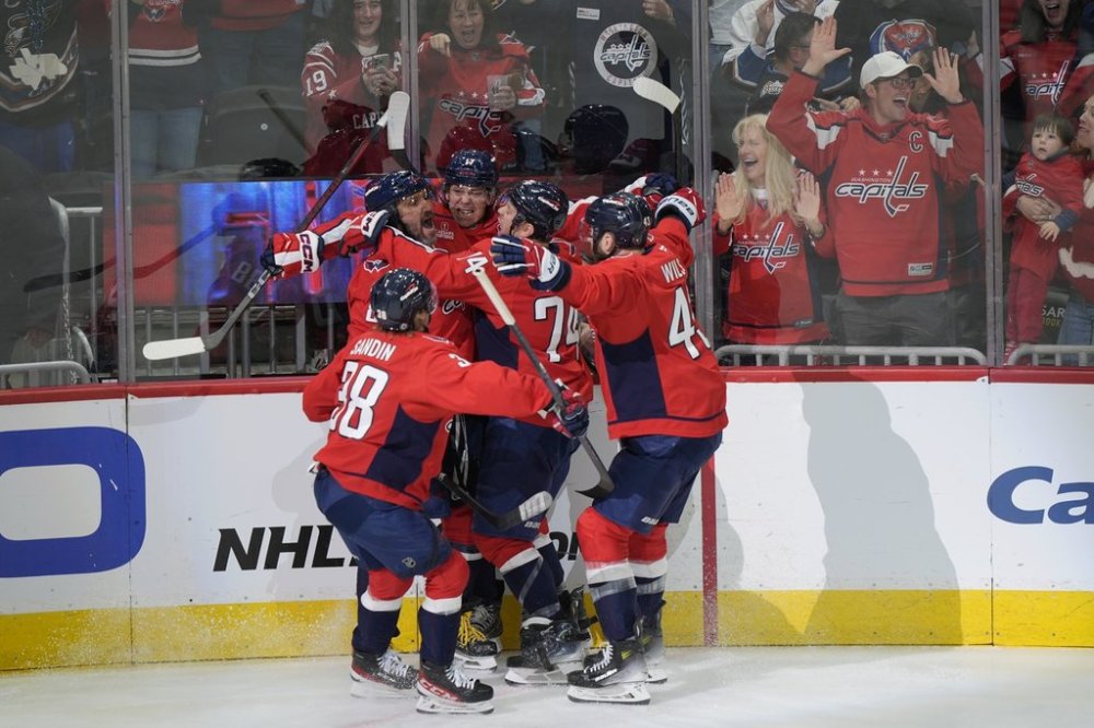 Washington Capitals left wing Alex Ovechkin (8) celebrated his 893 goal with his teammates during the first period of an NHL hockey game against the Chicago Blackhawks, Friday, April 4, 2025, in Washington. (AP Photo/Mark Schiefelbein)